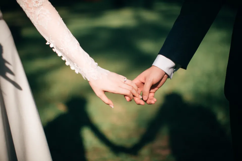Aynı eşle yeniden evlenme kararı veren, el ele tutuşan gelin ve damat