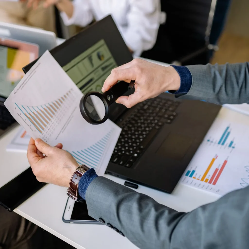 Büyüteçle grafik ve raporu inceleyen kişi: bilirkişi raporuna itiraz öncesi inceleme