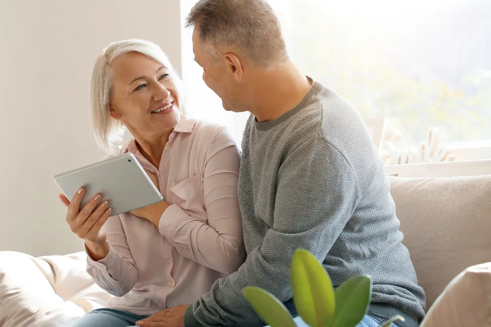 Tablet üzerinden emeklilik planına bakan orta yaşlı çift