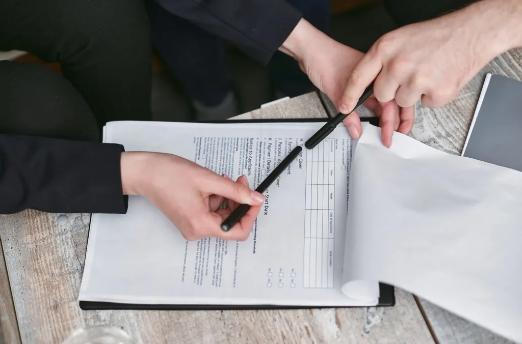 İki kişi kalemle bir formu inceliyor: ibranamenin geçerlilik şartları imzadan önce kontrol edilmeli