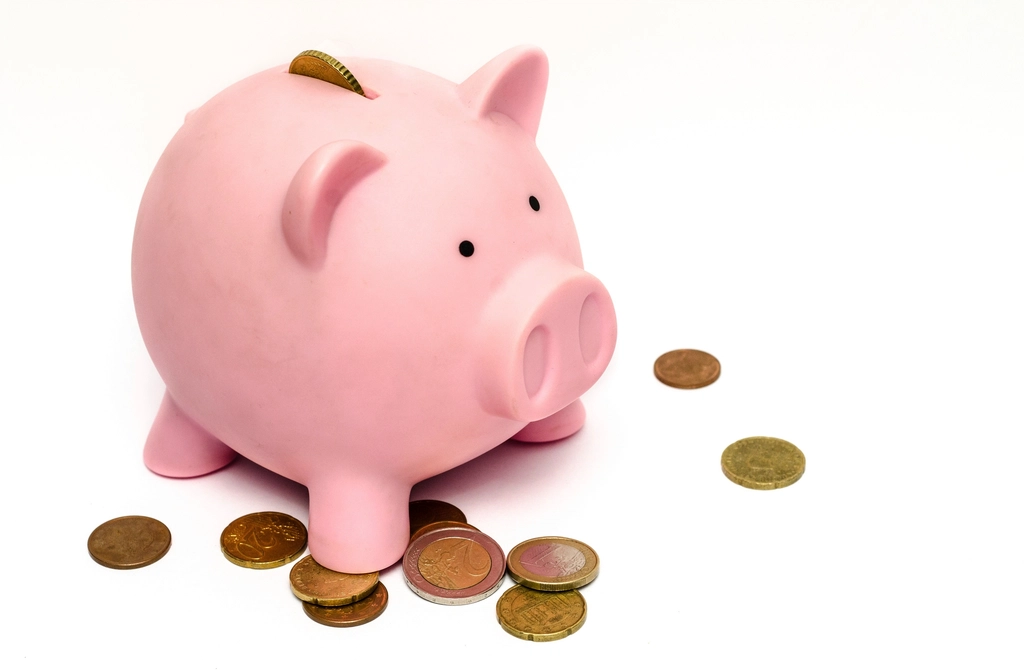Representative image of saving, with coins and a piggy bank standing on a table