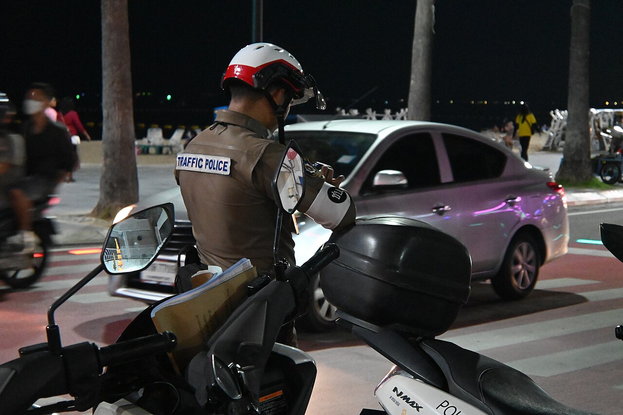A traffic officer checking accident report paperwork at the roadside after an accident