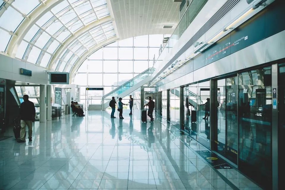 Geniş cam tavanlı terminal salonunda bekleyen yolcular, giriş yasağı ve terke davet konusu