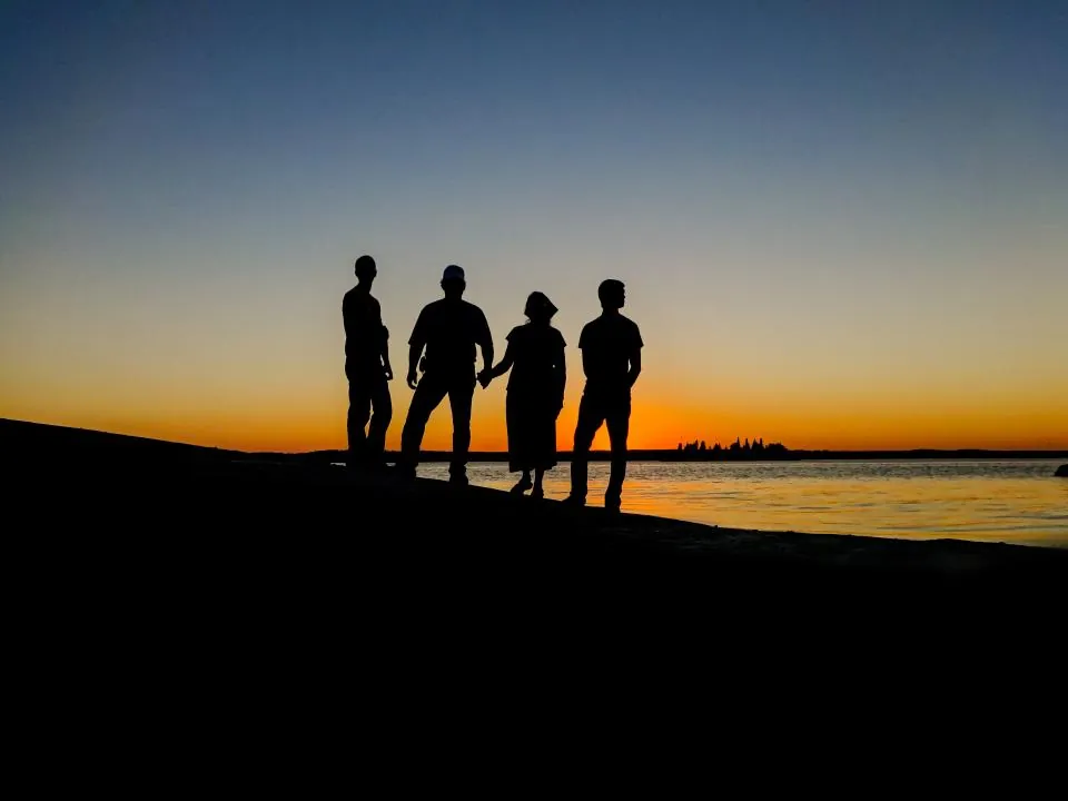 Gün batımında deniz kıyısında duran aile; yabancıların miras hakkı ve aile bağları
