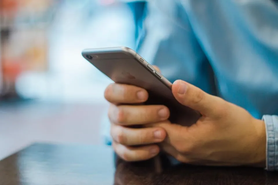 Barkodlu belgenin doğrulanması için akıllı telefon kullanan kişi