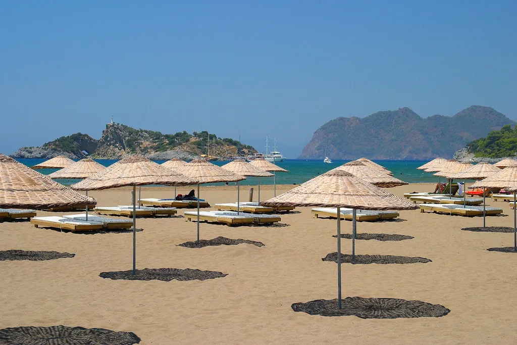 Hasır şemsiyeli Ege plajı: Çeşme dava süreci turizm sezonunun uyuşmazlıklarıyla yoğunlaşır