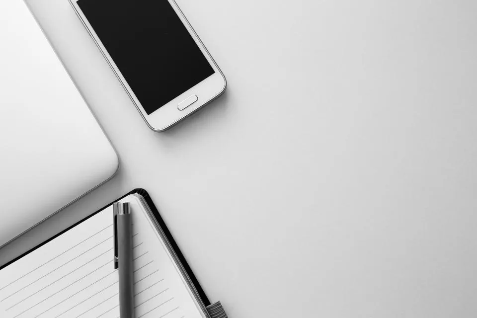 İcra dosyasını sorgulamak için masada telefon, defter ve kalem