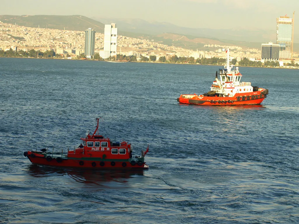 İzmir Körfezi'nde kılavuz ve römorkör tekneleri, arka planda körfez kıyısındaki kent