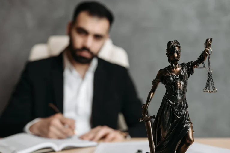 Konak ceza yargılaması dosyasını adalet heykeli yanında inceleyen avukat